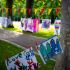 Kinderbilder an Leine im Park – Bunte Kinderzeichnungen hängen an einer Leine zwischen Bäumen im Park.